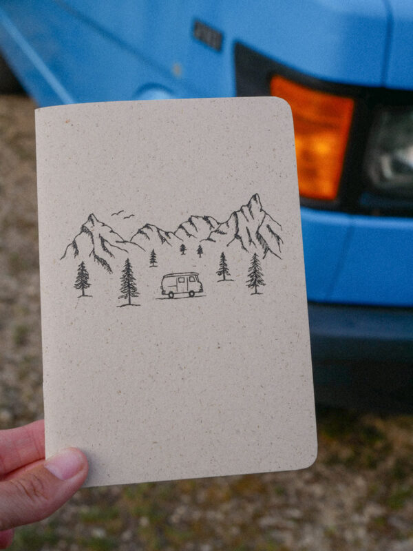 Naturfarbenes A6 Notizheft aus Graspapier mit schlichter Camping-Zeichnung auf dem Cover